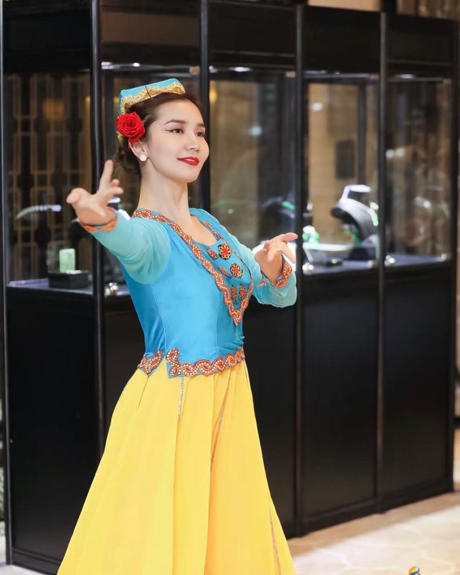 Alinuer Wumaer performing in a blue and yellow costume