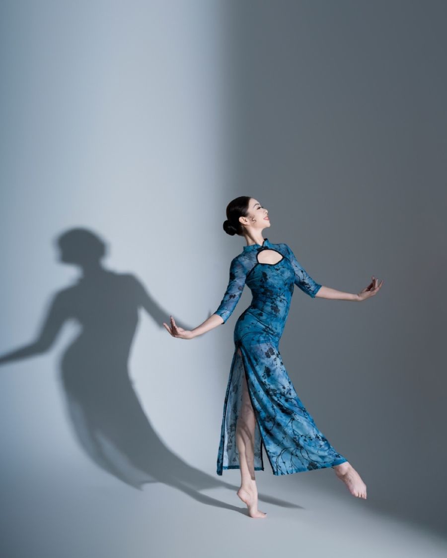 Grace Leung performing in a blue dress beside her shadow